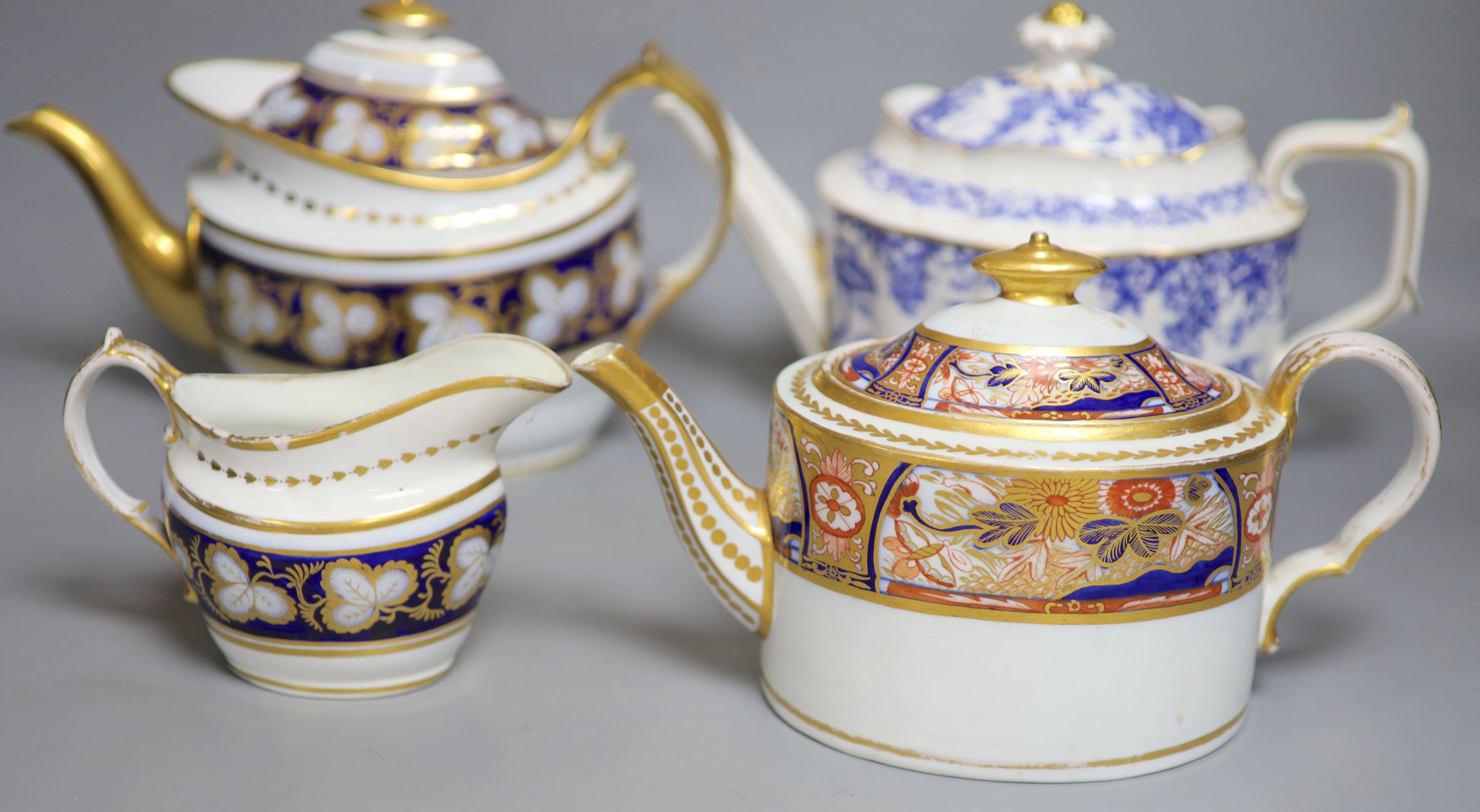 Three various porcelain teapots, a cream jug and a sucrier